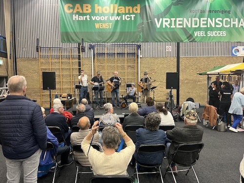 groepje mensen die luisteren naar band Shepperds Pie