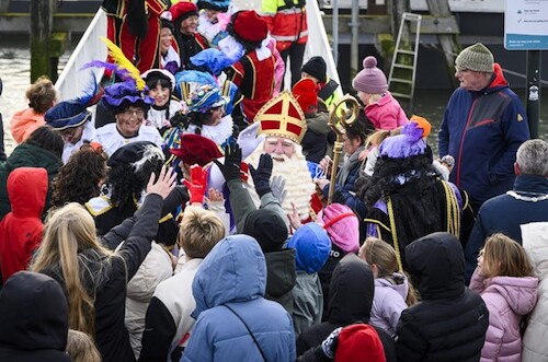 Sinterklaas tussen veel kinderen met zijn pieten
