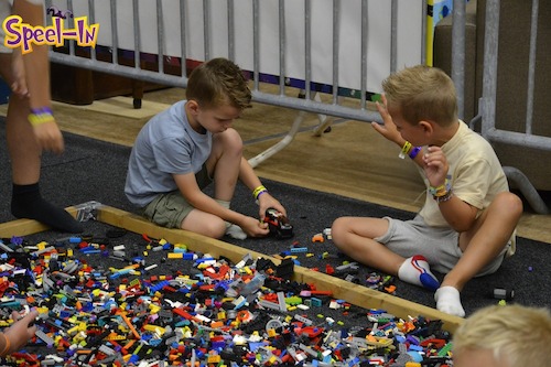 Twee jongentjes spelen op de grond met lego